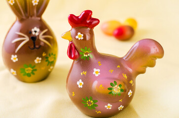 chocolate rooster and chocolate bunny on a light background with eggs