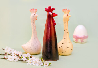 three chocolate cockerels on a light background with flowers