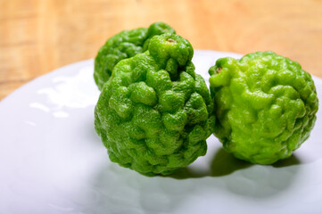 Citrus hystrix, kaffir lime or makrut lime, citrus fruit native to tropical Asia. Fruit and leaves used in Southeast Asian cuisine, essential oil is used in perfumery for intense citrus fragrance.