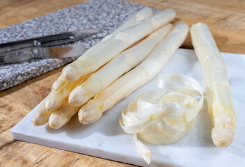 How to peel asparagus, spring season, new harvest of Dutch, German white asparagus, bunch of raw white asparagus