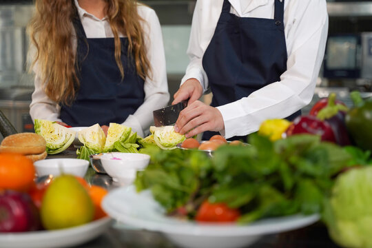 Close Up Hand Chef The Group Children Cut Vegetables In Class Kitchen Room.  Chef Preparing Student For Learning Marking And Cooking Food At Workshop.  Education Concept