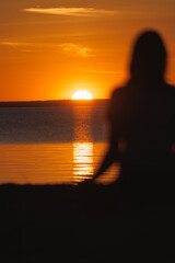 soft selective focus, yoga meditation, silhouette of woman at sunset in lotus position. health recreation and sports, outdoor training. person engaged in breathing practices seashore. mental health