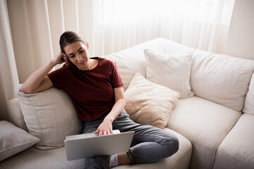 Young woman surfing the internet from home.