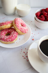 Donuts with coffee and milk. 
Donut with pink frosting 