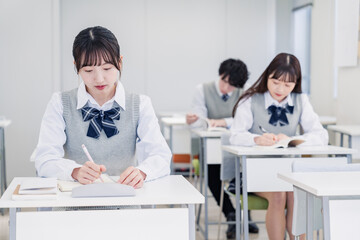 集中してノートを取る高校生
