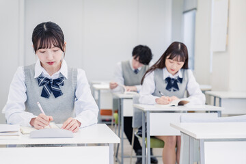 集中してノートを取る高校生