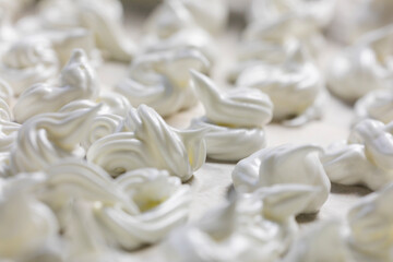 close-up of classic white meringue laid out on foil before baking. Festive mood