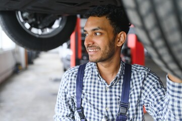 service, repair and profession concept - indian mechanic at car service