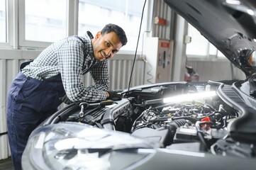 Indian happy auto mechanic in blue suit.