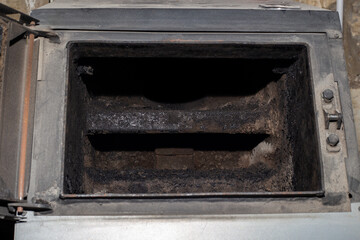 The furnace of a solid fuel boiler in soot. Boiler cleaning and maintenance