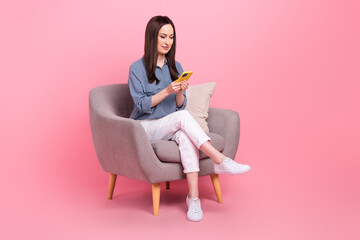 Full length photo of confident influencer business blogger mature age texting woman colleagues sitting armchair isolated on pink color background