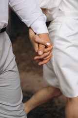 The touch of the hands of a man and a woman. Strong gentle hugs by the hands of two lovers. Young couple's hands close up. The feeling of love