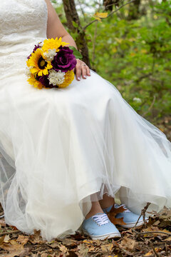 Bride with sunflower bouquet and blue sneakers waist down portrait