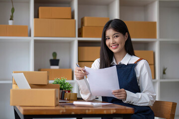 Startup small business entrepreneur SME, asian woman packing cloth in box. Portrait young Asian small business owner home office, online sell marketing delivery, SME e-commerce telemarketing concept.