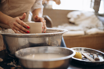 Woman working on pottery wheel creating a bowl