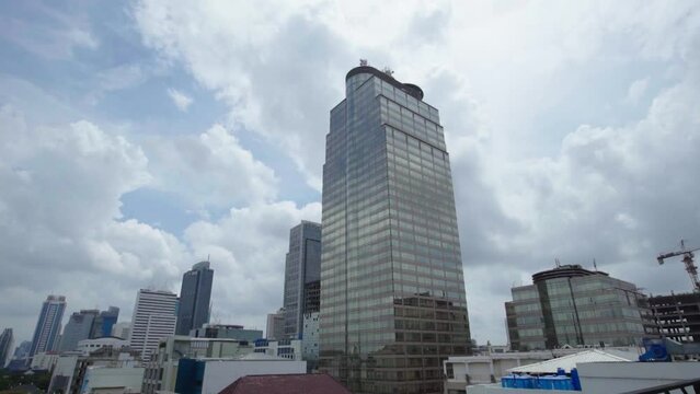 View of Office and Commercial Buildings in Jakarta Indonesia against a clear blue sky with moving clouds.
