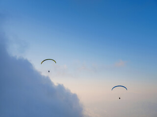 Paragliding in sky. Paraglider tandem flying over sea and mountains in cloudy day. view of...