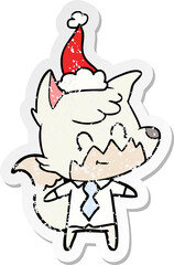 distressed sticker cartoon of a friendly fox wearing santa hat