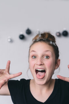 teen with hair bun and snowflakes making silly faces