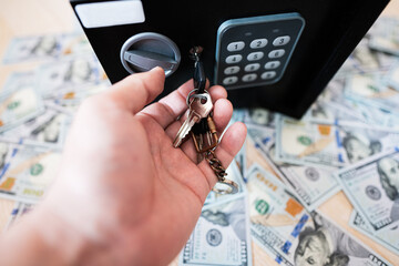 Male open with keys lock safe door against dollar money.