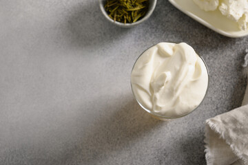 Cheese Tea with creamy foam topped matcha powder on gray background. Asian trendy beverage. Close up. Copy space. View from above.