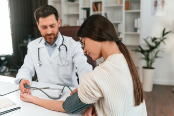 Obraz premium Blood pressure measurement. With woman. Doctor in formal clothes is working in the cabinet