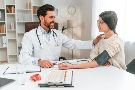 Blood pressure measurement. With woman. Doctor in formal clothes is working in the cabinet