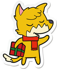 sticker of a friendly cartoon fox with christmas present
