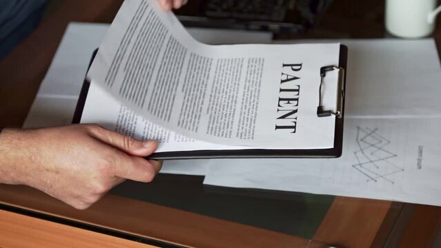 A man looks through patent documents. Legal due diligence of documents. Copyright registration.