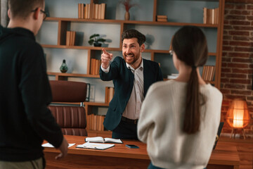 The boss shouts at subordinates. Businessman in formal clothes is working indoors