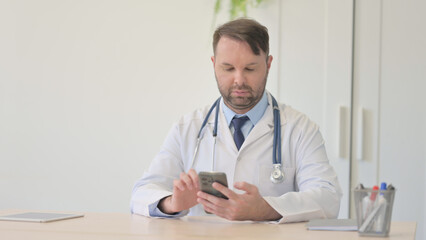 Young Doctor Using Smartphone at Work 