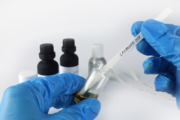 Fototapeta premium chemical beaker , flask is in left hand with blotting paper , fragrance bottle and essential oil bottle are used to blend the nice scent for making perfume and candle by perfumer in the laboratory