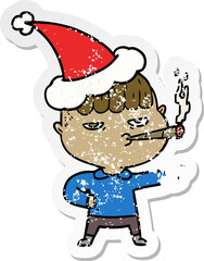 distressed sticker cartoon of a man smoking wearing santa hat