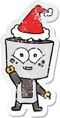 happy distressed sticker cartoon of a robot waving hello wearing santa hat