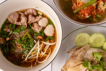 Noodles with pork and pork balls with soup Thai style in white bowl