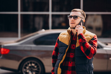 Handsome man standing by the car