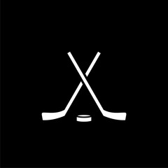 Crossed hockey sticks and hockey puck isolated on black background.