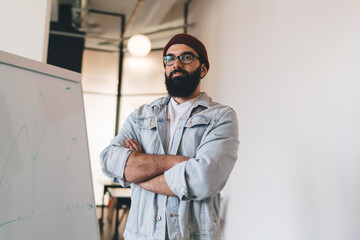Confident hipster guy looking away at workplace