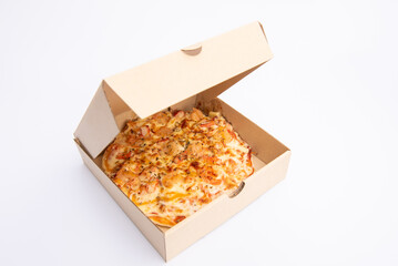 Close up of a Pizza in a cardboard box against on white background.Pizza delivery. Pizza menu.