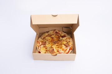 Close up of a Pizza in a cardboard box against on white background.Pizza delivery. Pizza menu.
