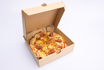 Close up of a Pizza in a cardboard box against on white background.Pizza delivery. Pizza menu.