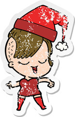 distressed sticker of a happy cartoon girl wearing xmas hat