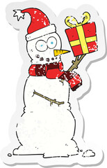 retro distressed sticker of a cartoon snowman holding present