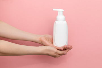 Female Hands Holding Blank White Dispenser Bottle, Plastic Tube On Pink Background. Hygiene, Cosmetic Beauty Product, Washing, Cleansing Intimate Gel, Foam. Daily Body Care. Horizontal Plane, Closeup