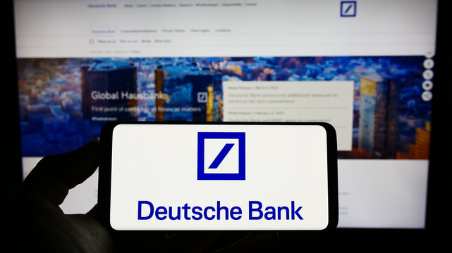 Stuttgart, Germany - 03-25-2023: Person holding cellphone with logo of German financial company Deutsche Bank AG on screen in front of business webpage. Focus on phone display.