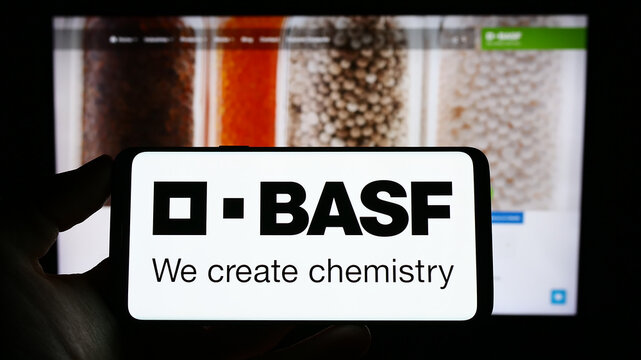 Stuttgart, Germany - 03-25-2023: Person holding cellphone with logo of German chemical company BASF SE on screen in front of business webpage. Focus on phone display.