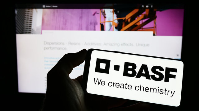 Stuttgart, Germany - 03-25-2023: Person holding smartphone with logo of German chemical company BASF SE on screen in front of website. Focus on phone display.