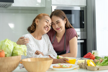 Obraz na płótnie Canvas activities together during the holidays. mother and daughter are having a meal together during the holidays. asian female prepare breakfast on morning, enjoy, weekend, vacant, family time, happy.