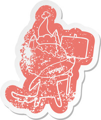 cartoon distressed sticker of a wolf with sign post showing teeth wearing santa hat