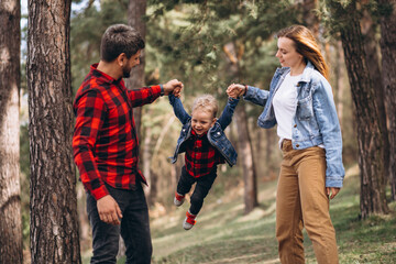 Family with little son together in the forest